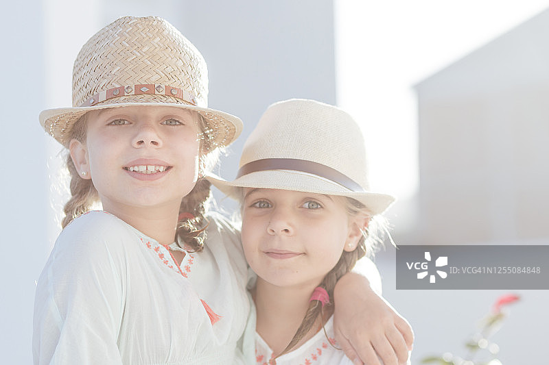 可爱的双胞胎女孩戴着帽子在阳光明媚的日子图片素材