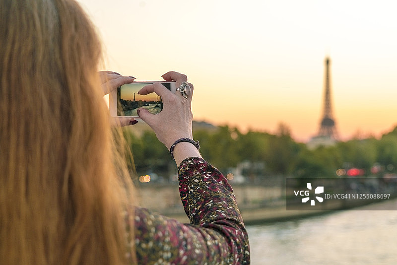 法国，巴黎，女人正在用手机拍照图片素材