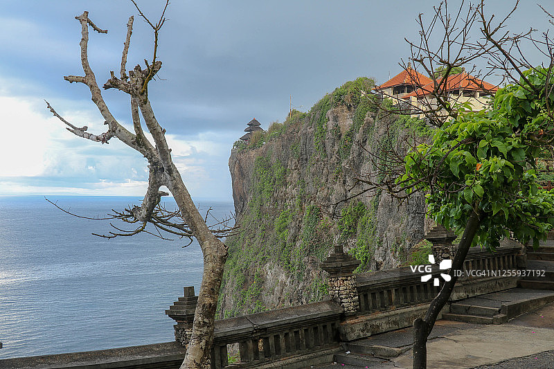 印尼巴厘岛乌鲁瓦图悬崖与凉亭和蓝色的大海。Uluwatu是位于Uluwatu的巴厘岛印度教海上寺庙。它以其宏伟的地理位置而闻名图片素材
