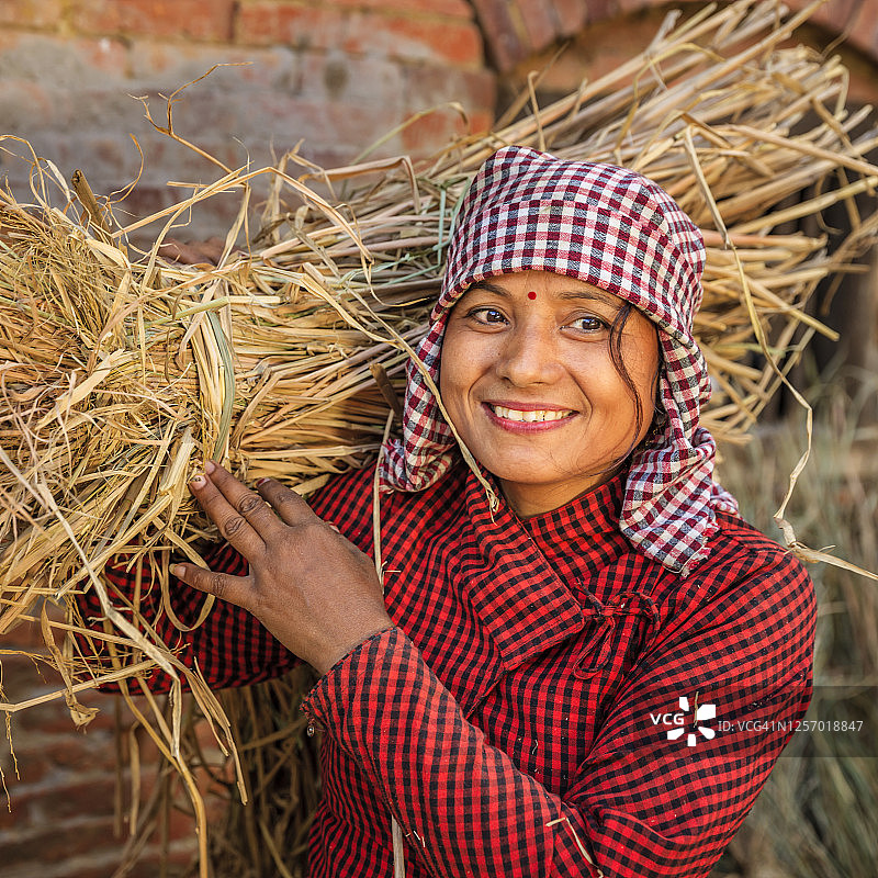 年轻的尼泊尔妇女拿着一根稻草图片素材