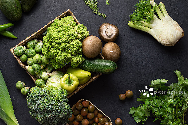 绿色蔬菜和食物背景。健康饮食理念的黑餐桌上的新鲜有机产品图片素材