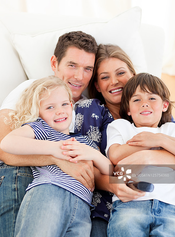一家人坐在沙发上看电视图片素材