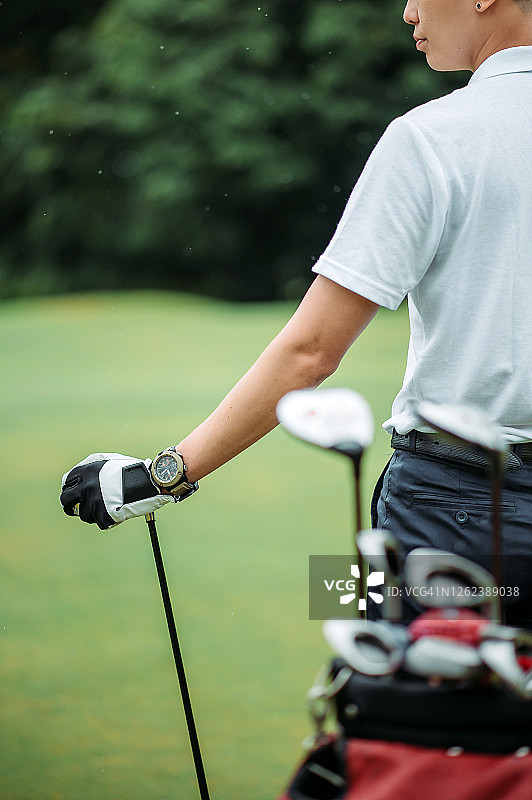 亚洲年轻男子高尔夫球手在高尔夫球场驾驶俱乐部的Crop shot图片素材