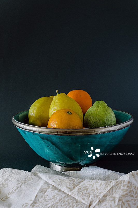 青绿色的碗，清新的柑橘，橙，柠檬和酸橙。图片素材