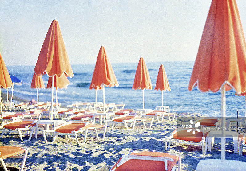 橙色的沙滩伞和沙滩躺椅图片素材
