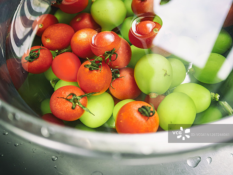 将樱桃番茄和绿葡萄混合在水中形成的抽象图案图片素材