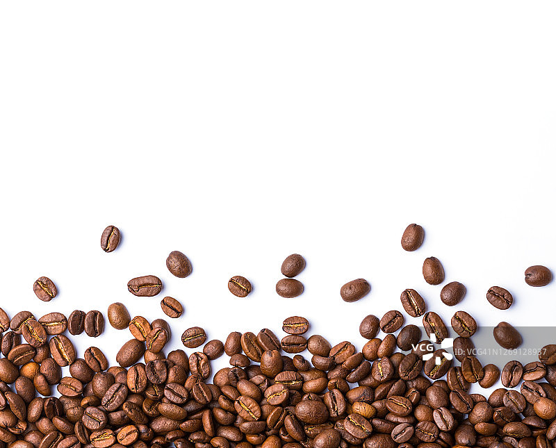在白色背景下分离的棕色烘焙咖啡豆。食品的背景。图片素材