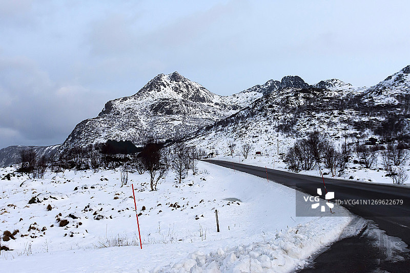 挪威罗浮敦群岛，蜿蜒的道路穿过风景秀丽的雪山图片素材