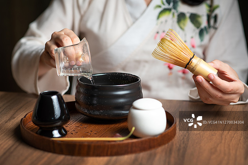 女人用传统的茶道用具制作抹茶绿茶图片素材