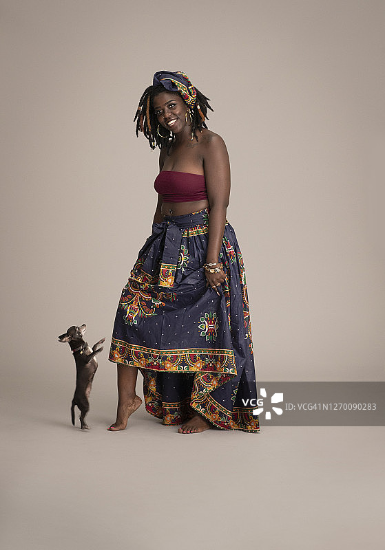 穿着传统非洲服装和吉娃娃跳舞的非洲裔美国妇女图片素材