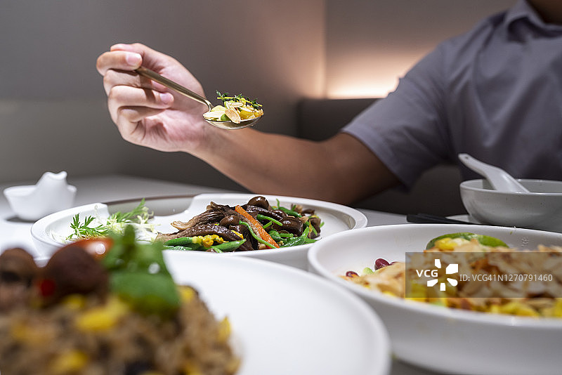 亚洲男子在餐桌上享受素食图片素材