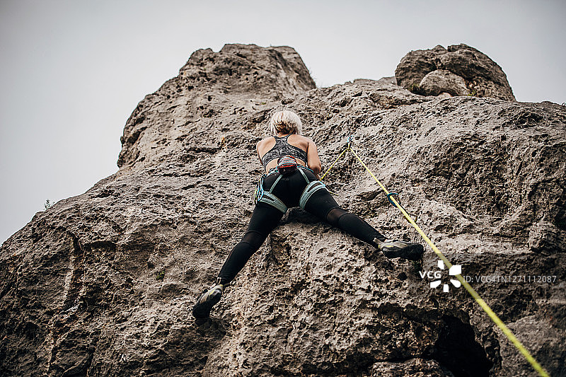 一位年轻的女性极限攀登者正在爬山图片素材
