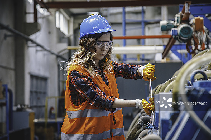 工业机械女工在工厂使用大型工具工作图片素材