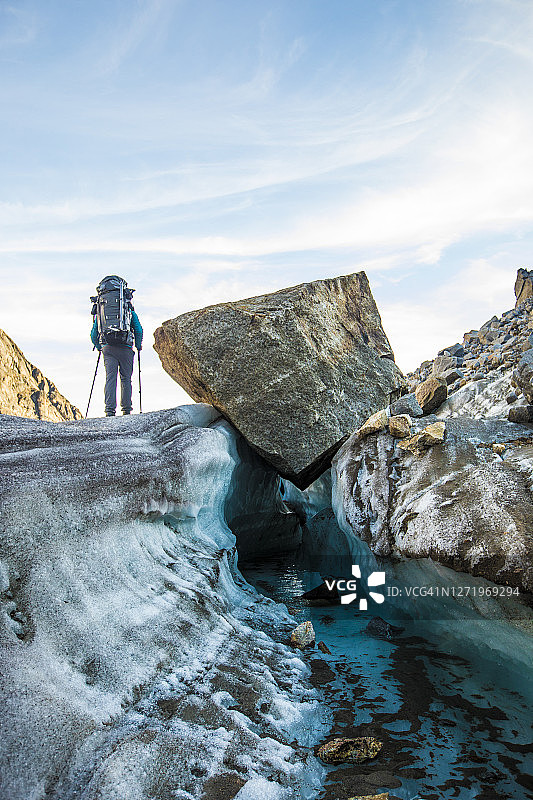 背包客徒步穿越阿克沙亚克山口的冰川图片素材