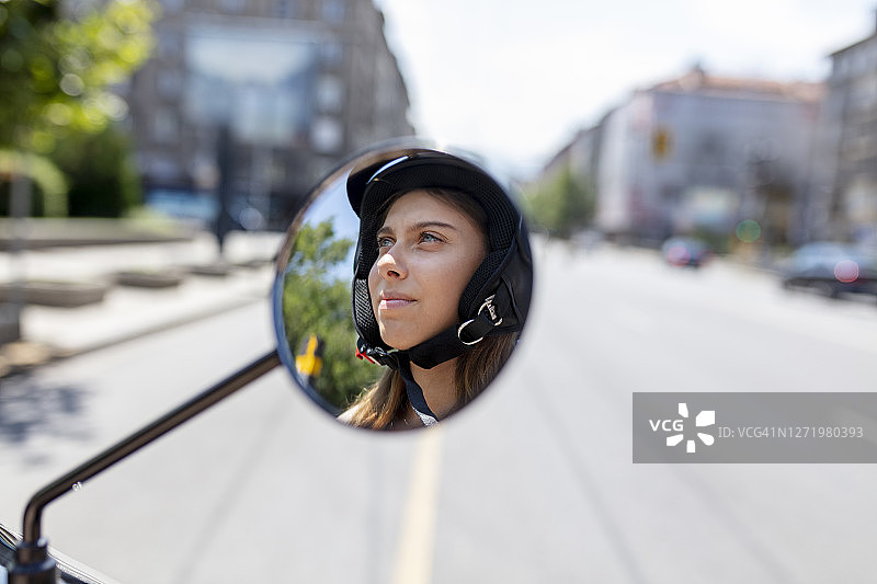 女人的脸在摩托车的侧视镜图片素材