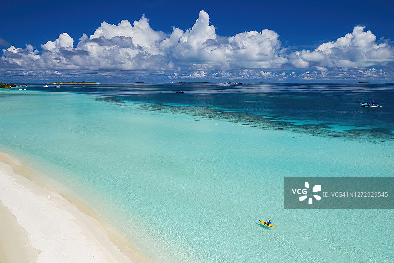 鸟瞰女子皮划艇在清澈的热带水域，马尔代夫图片素材