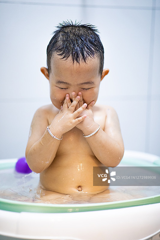 宝宝在洗澡时自己洗脸图片素材
