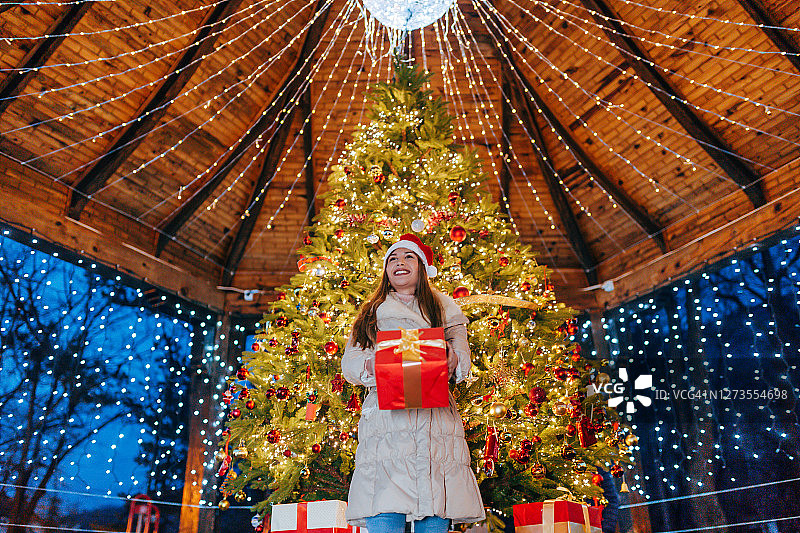 一个女人站在圣诞树前图片素材