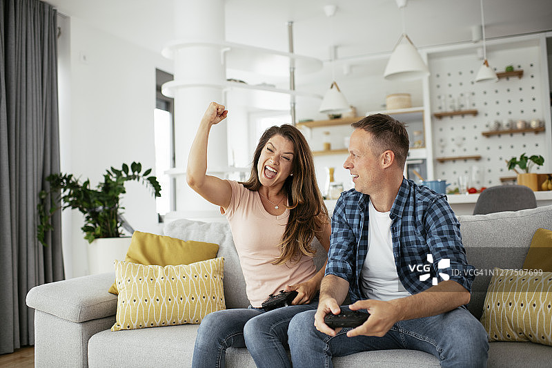 丈夫和妻子在客厅用操纵杆玩电子游戏。图片素材
