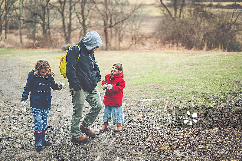 父亲和女儿们冬天在树林里散步图片素材