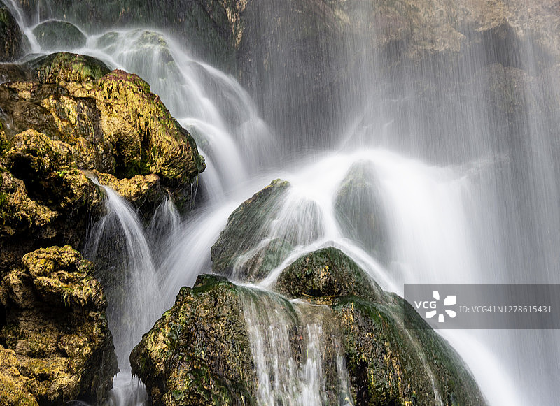 河流和瀑布清澈的水，落在岩石之间的大自然。图片素材