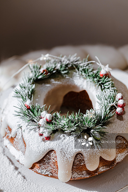 传统的圣诞柠檬蛋糕装饰云杉枝和蔓越莓。图片素材