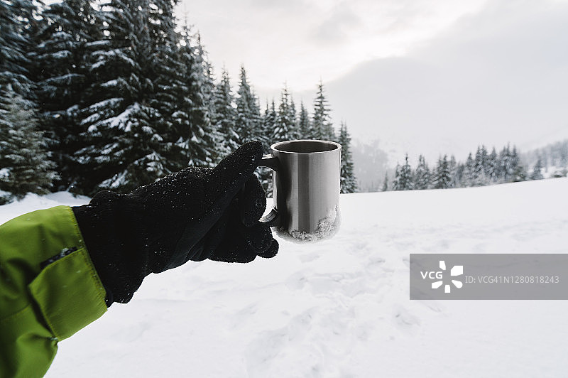 手握咖啡杯对着雪山全景图片素材