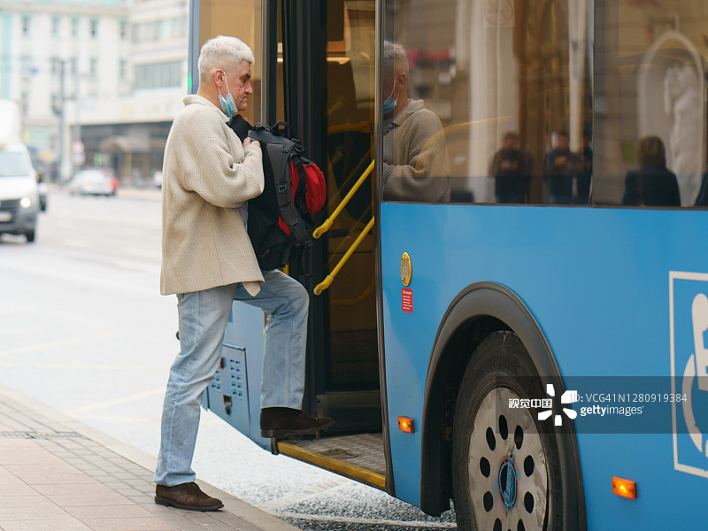 一名男子在莫斯科街头上了一辆蓝色巴士图片素材