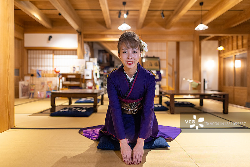 年轻女子在“Furisode”和服坐在高跟鞋在日本榻榻米房间图片素材