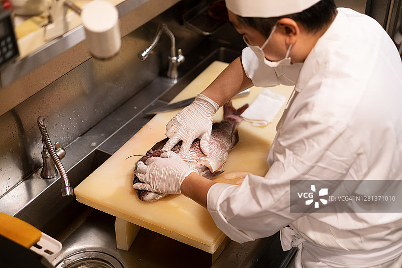 厨师在日本餐厅厨房烹饪海鲷的特写图片素材