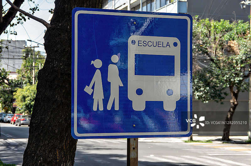 市内街道上的西班牙语道路警告标志，指示着一个学校巴士站图片素材