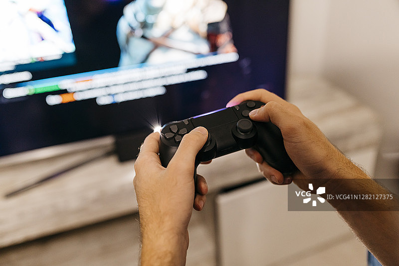 男性玩家手握控制器在家玩游戏图片素材