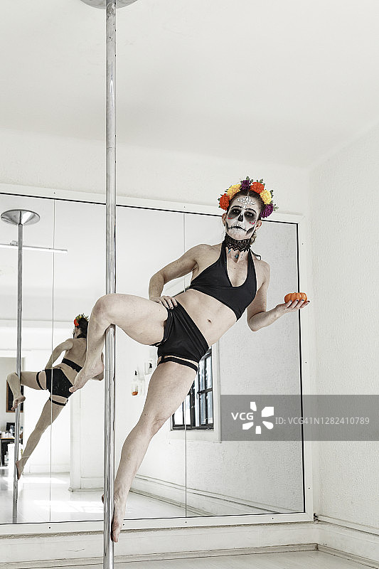 一个钢管健身女运动员用卡拉维拉化妆庆祝死者的日子图片素材