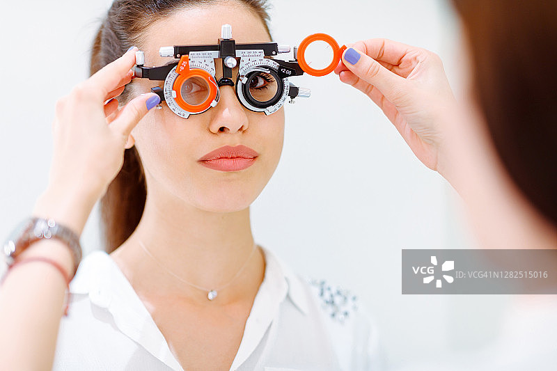 年轻女子戴着光镜，医生换镜片图片素材