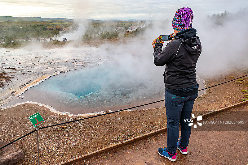 一名女子在冰岛盖西尔温泉区拍摄温泉图片素材