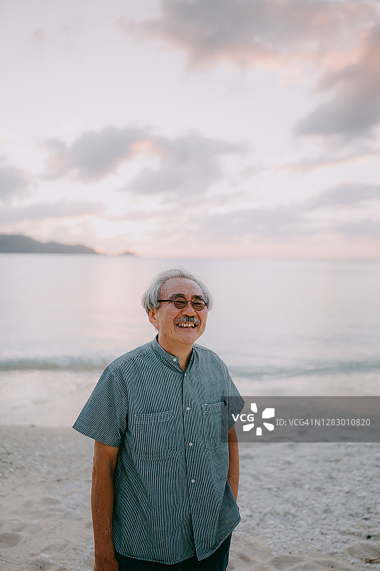日落时分海滩上兴高采烈的日本老人图片素材