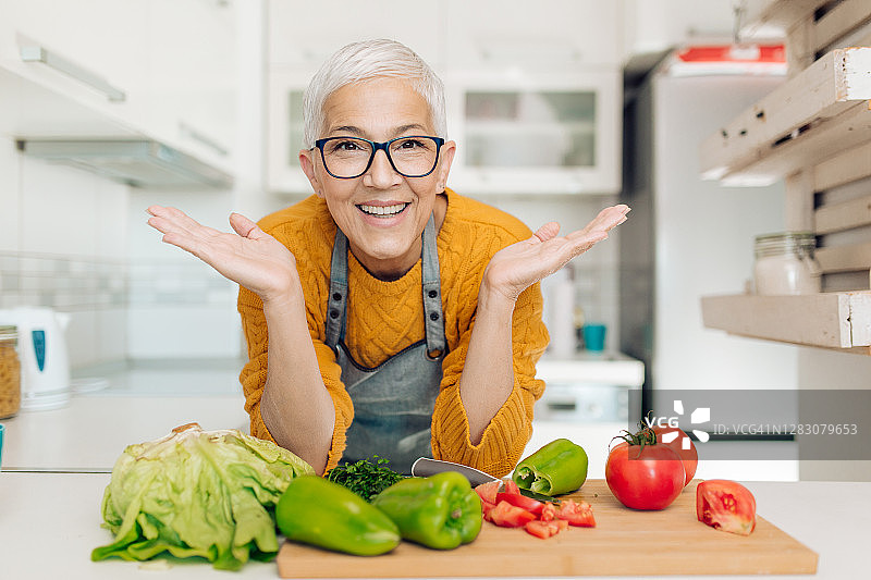 一个快乐的成熟素食主义者在厨房的肖像图片素材