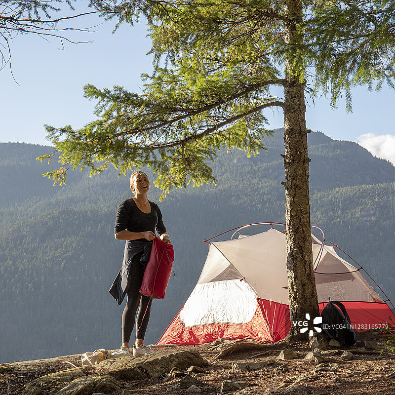 一个年轻女子在山脊上搭起了一个帐篷图片素材