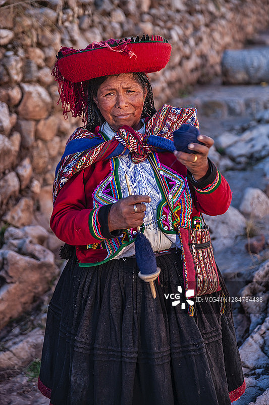 秘鲁圣谷，一名秘鲁妇女在手工纺羊毛图片素材