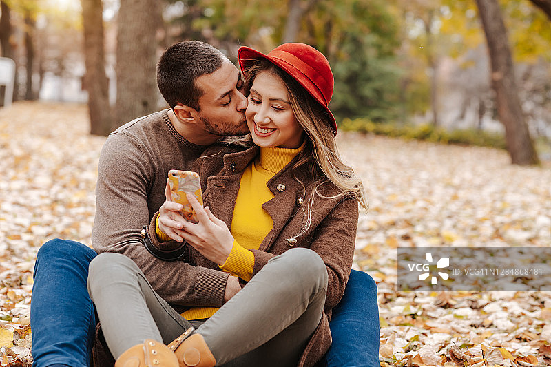 秋日情侣用手机在大自然中自拍图片素材