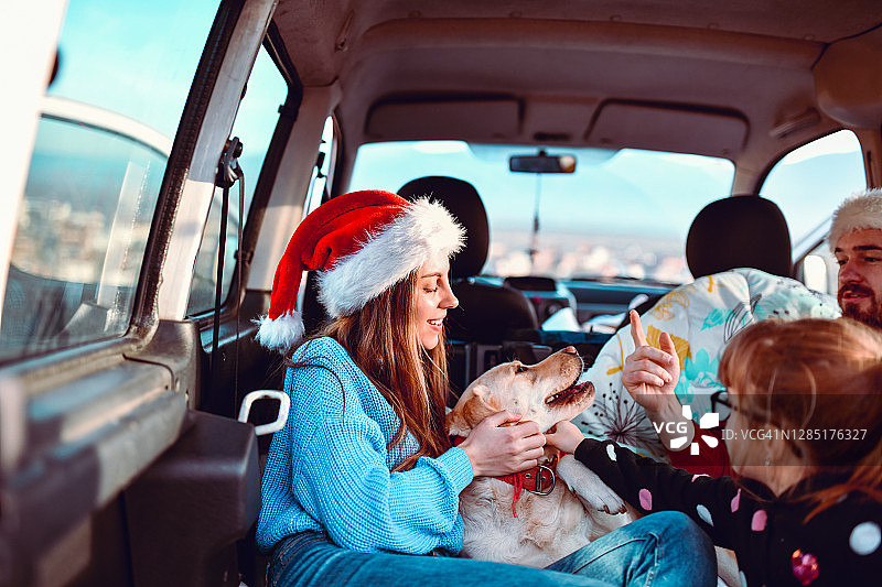 快乐的家庭与狗享受圣诞小货车公路旅行图片素材