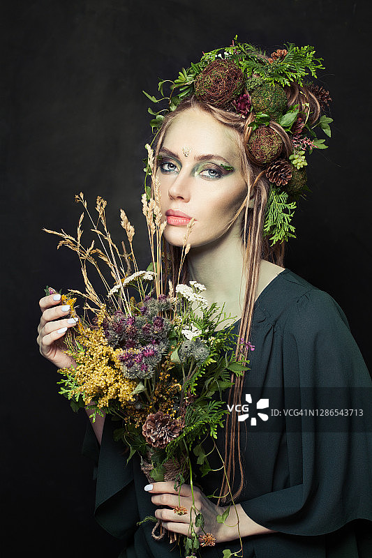 万圣节人物女人有创意的化妆，花，绿色的叶子和树皮上的黑色图片素材