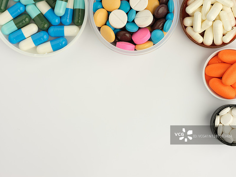 圆形容器内的彩色药品，白色背景，俯视图图片素材