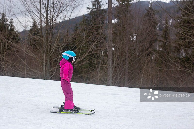 一个孩子在滑雪坡上滑雪。图片素材