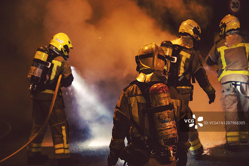 消防队员在夜间紧急灭火时的行动。图片素材