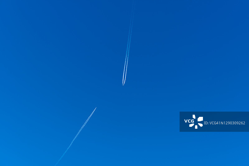 蓝色天空中两架客机的尾迹图片素材