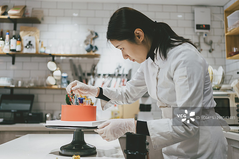 亚洲女孩在工作室做蛋糕图片素材