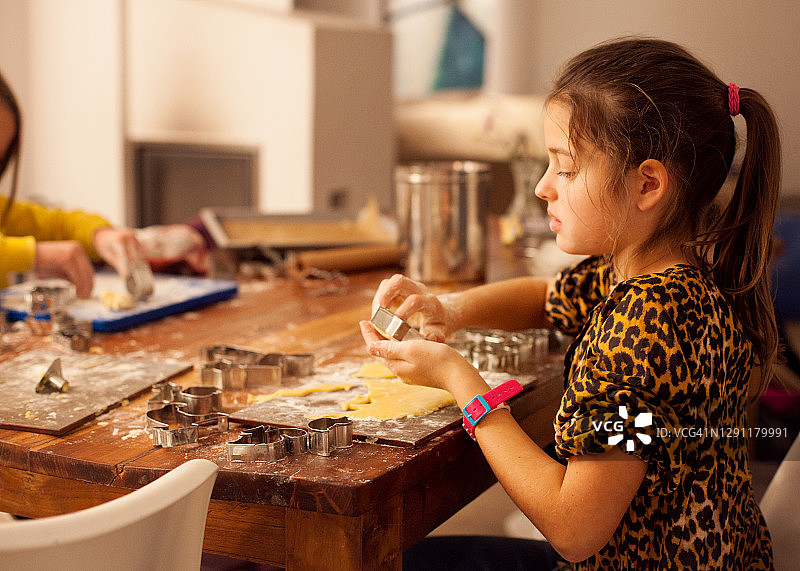 小女孩在餐桌上做饼干图片素材