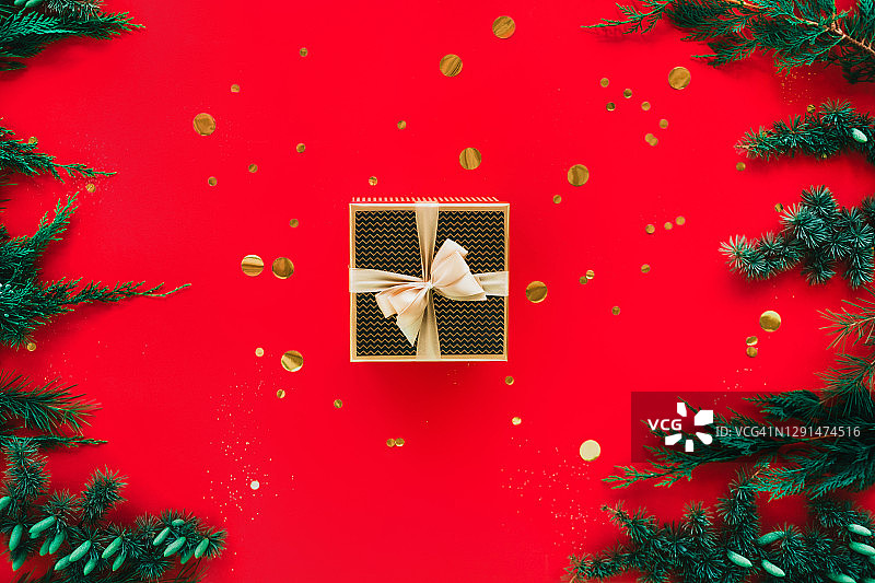 在五彩纸屑和针叶树枝之间的礼盒。新年来临概念图片素材