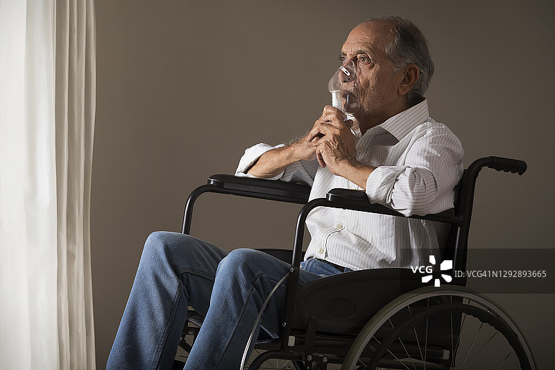 老人坐在轮椅上，戴着氧气面罩。(健康)图片素材